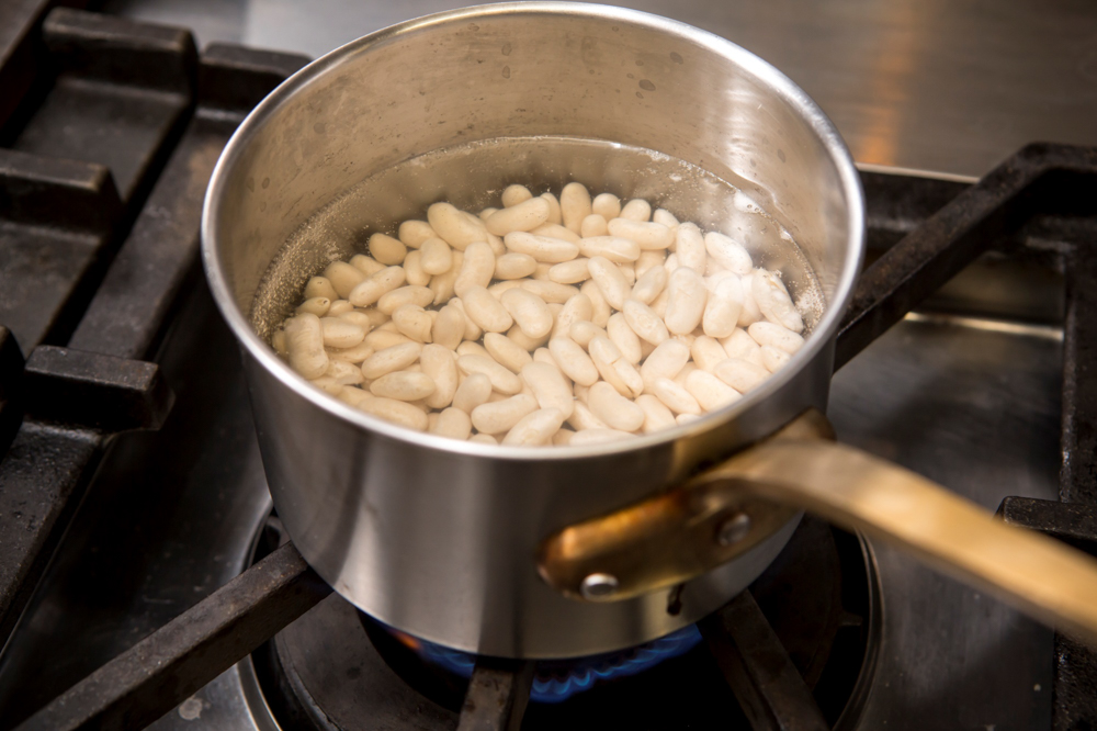 水を捨てて鍋に入れ、たっぷりの水（分量外）で茹でる。沸騰までは強火、沸騰したらごく弱火で、アクを取りながら１時間半～２時間煮る。