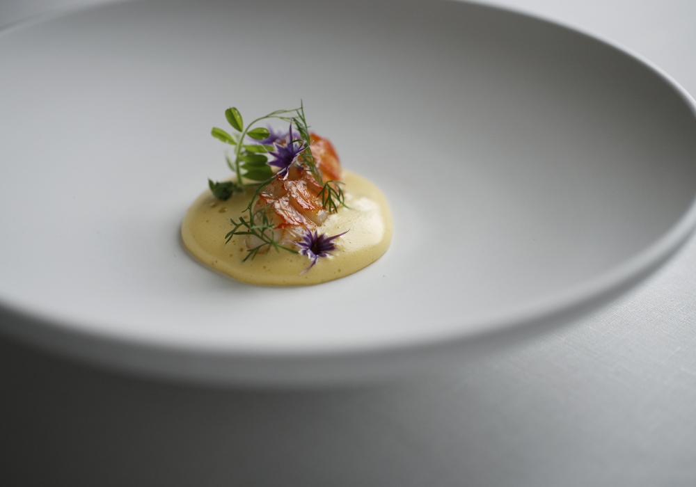 伊勢海老を殻付きのまま炭火で焼き、サービスマンが客前で殻を外して皿の上へ。柑橘風味のサバイヨンソースと共に。