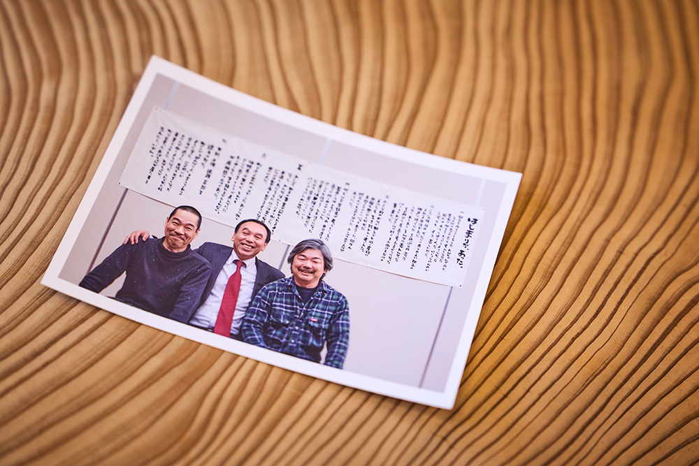 馬路村の写真とデザインを手がけるカメラマンとデザイナーとの３ショット。真ん中が東谷さん。