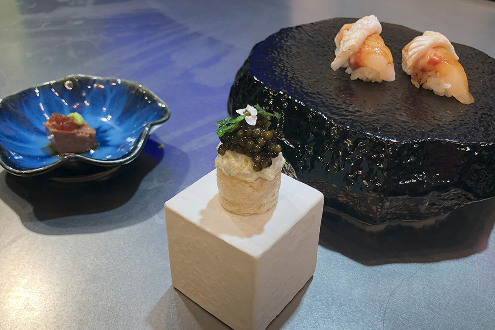 スズキの皮を揚げて身を詰めた料理は中央。左が肝の料理、右は握りずし。