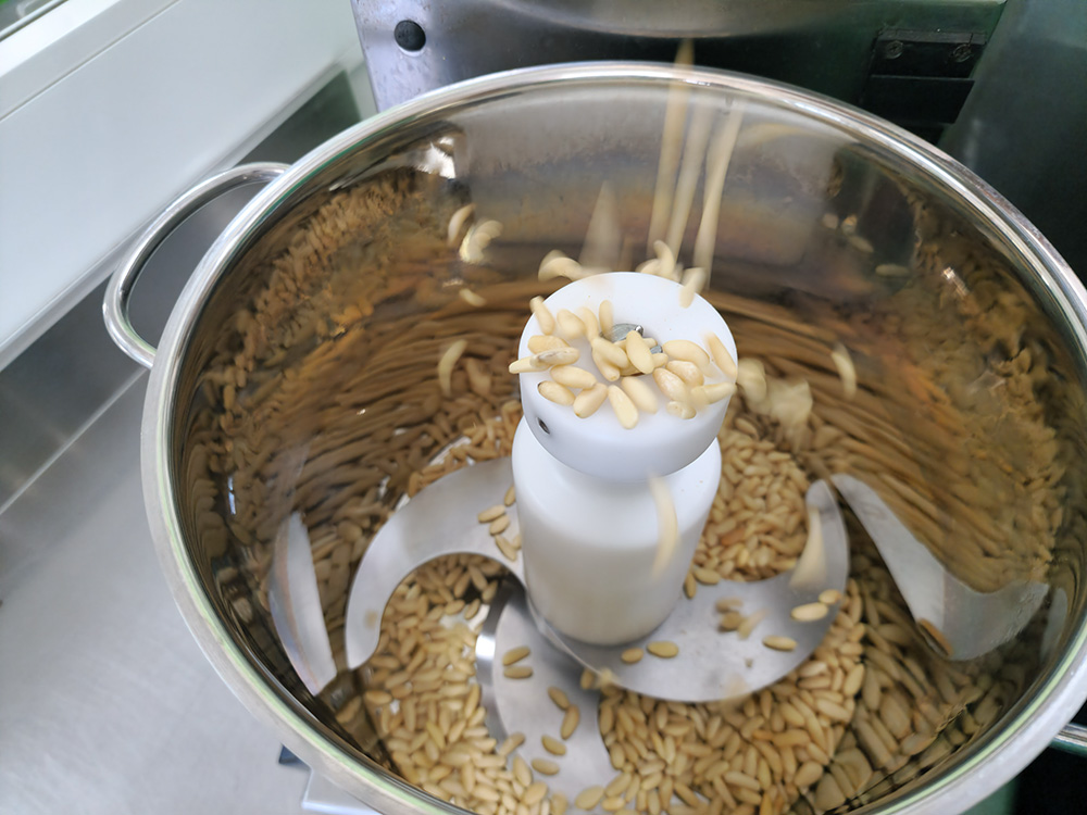 一級品の松の実を刻んだものとニンニクをミキサーにかけて粉砕
