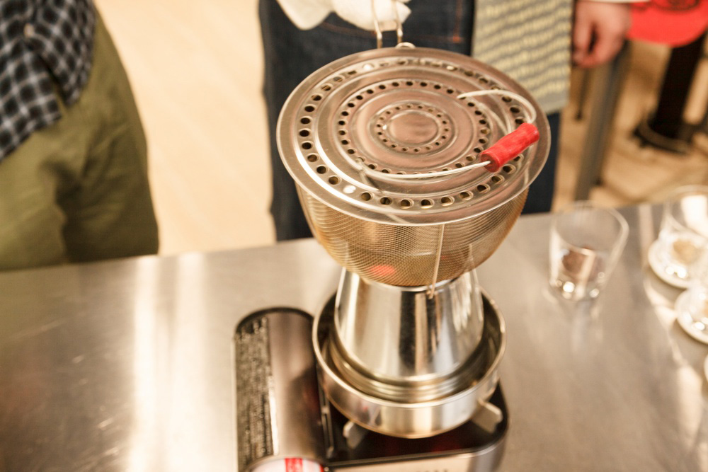 ［３］豆をザルに入れ、揺すりながら温める