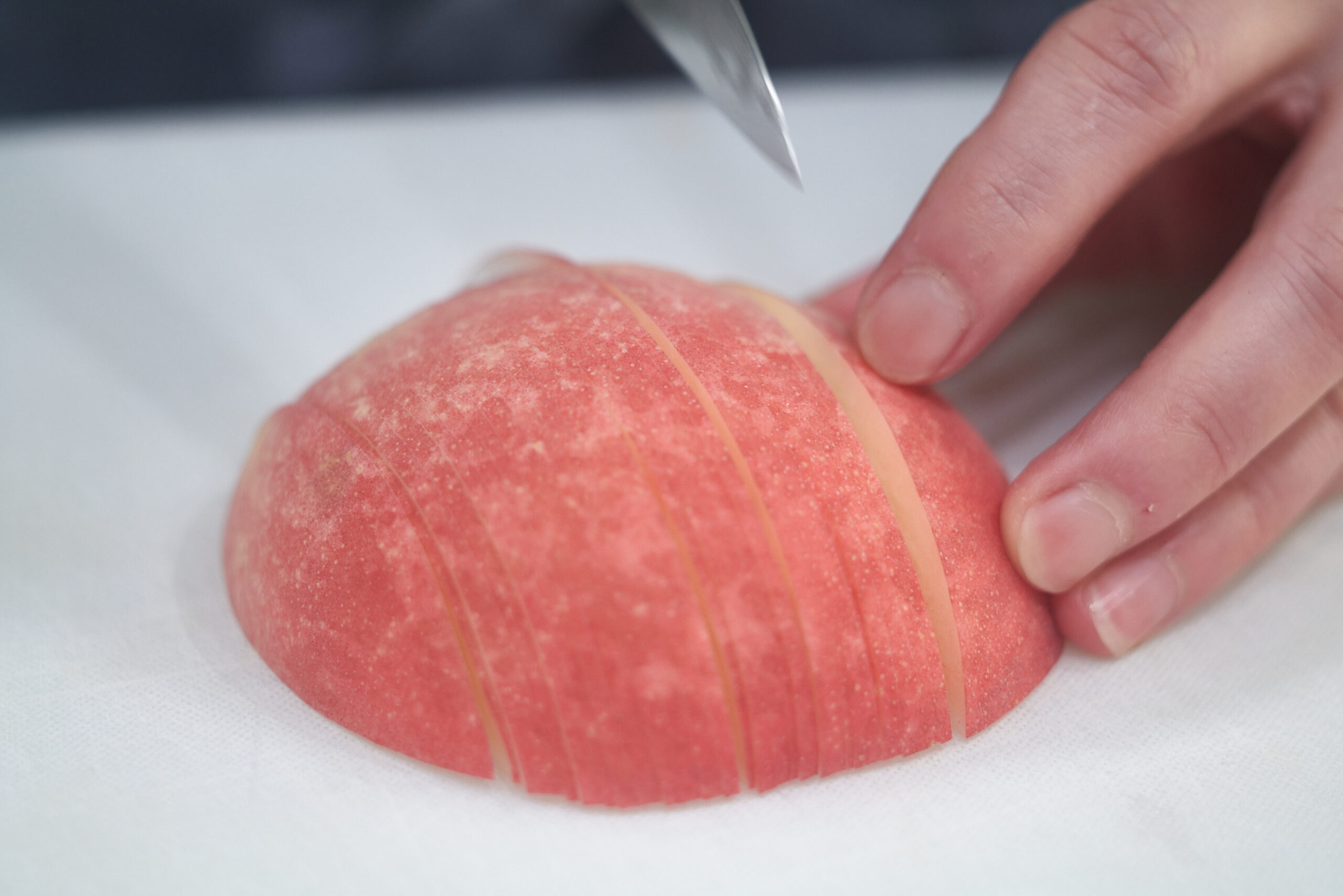焼きタルトに使う「幸茜」は、皮付きのまま１～２㎜幅に薄くスライス。